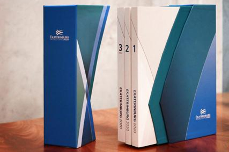 Три тома заявочной книги Экспо-2020 и картонный короб под них.