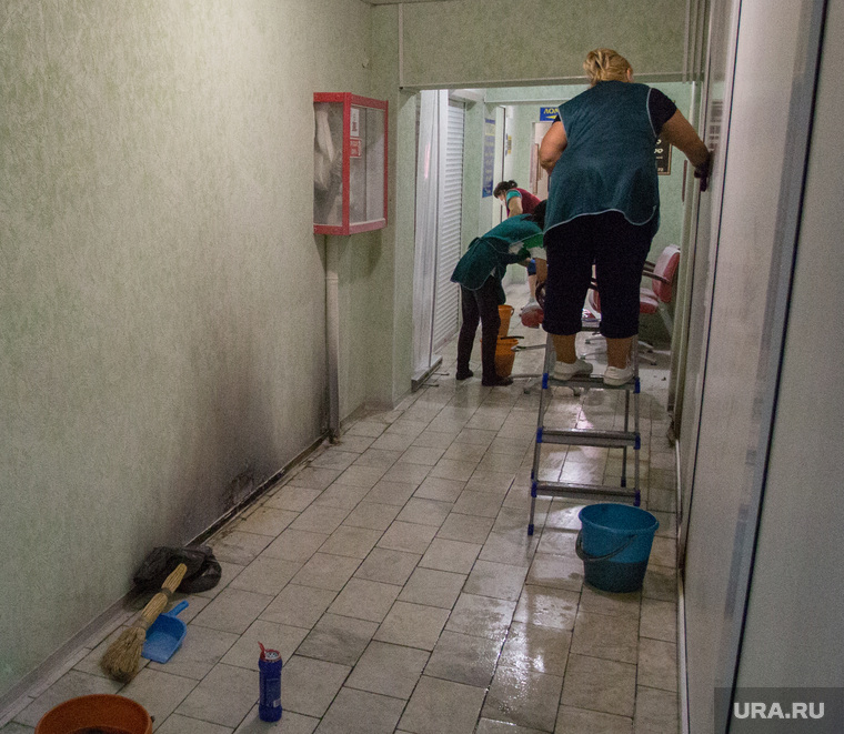 Сотрудники торгового центра «Северный» отмывают стены и пол после взрыва пакета, брошенного неизвестным