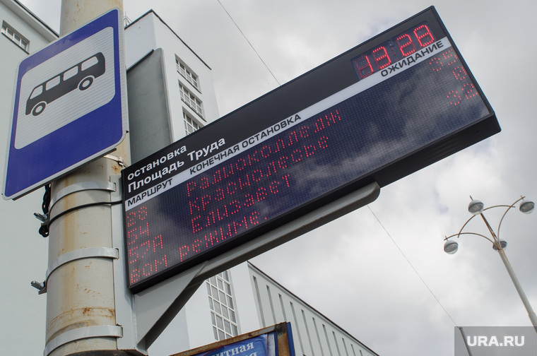 Табло показывает время ожидания автобусов на остановках. По мнению замерзших людей, транспорт ходит отвратительно