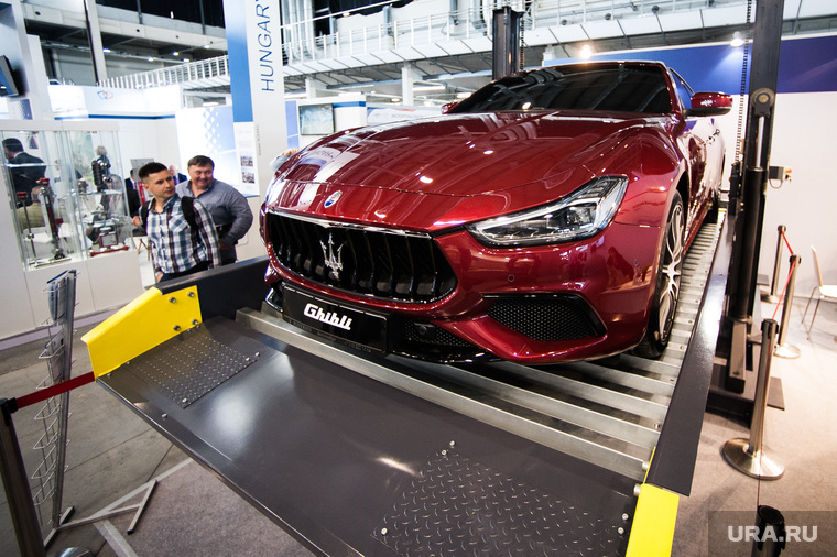 Красная Maserati привлекает внимание к механизированной парковке- когда на платформу заезжает авто, она поднимается, и появляется дополнительное машиноместо