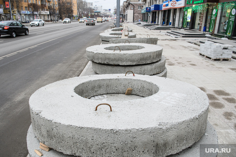 Бетонные кольца лежат прямо на тротуаре