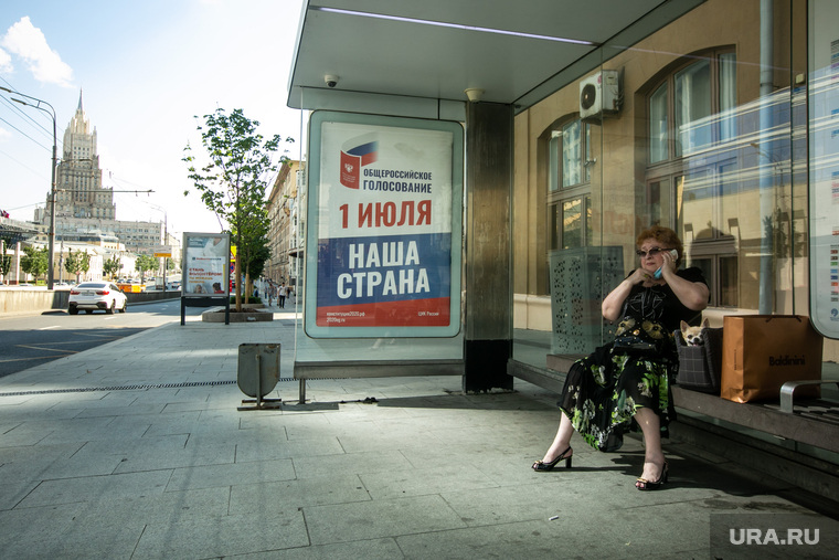 Москвичка на остановке возле МИДа. Агитация напоминает о приближении голосования за поправки в Конституцию РФ