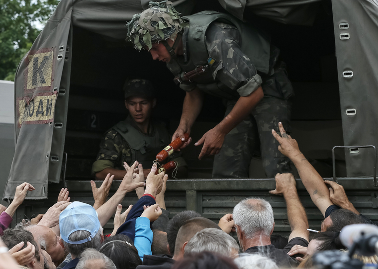 6 июля 2014 года. Люди получают продовольственную помощь от солдат ВСУ в Славянске, который возвращен под контроль Украины. На кадрах — мирные жители тянутся к продуктам, которых не хватало в городе.