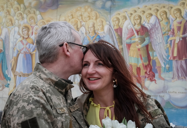 26 марта 2022 года. Фото из Киева. Мужчина целует свою невесту Иванну в центре города