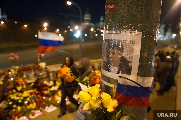 Люди несут цветы на место гибели Бориса Немцова после того, как мемориал был разрушен ночью. Москва, Немцов