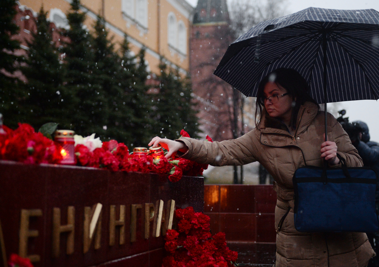 Люди несут цветы в память о жертвах теракта в петербургском метро