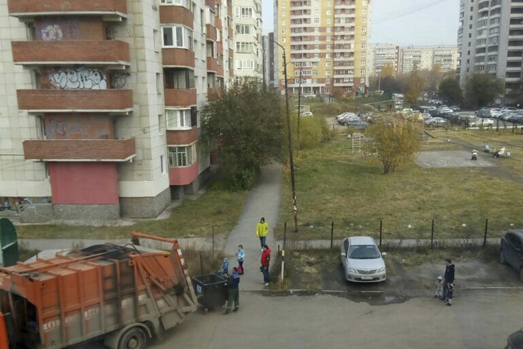 Часть бытовых отходов ТСЖ перебрасывают в погрузчик вручную через забор