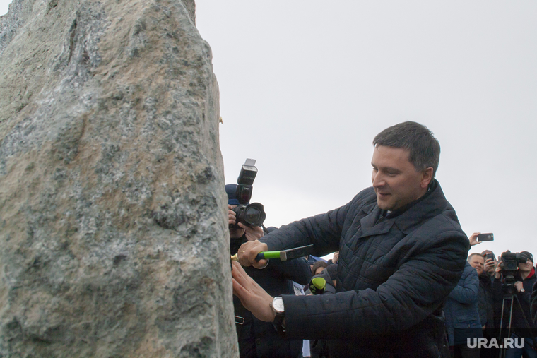 Губернатор Кобылкин прибивает к камню мемориальную табличку