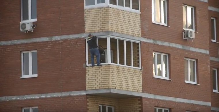 Мужчина вылез с балкона наружу без страховки