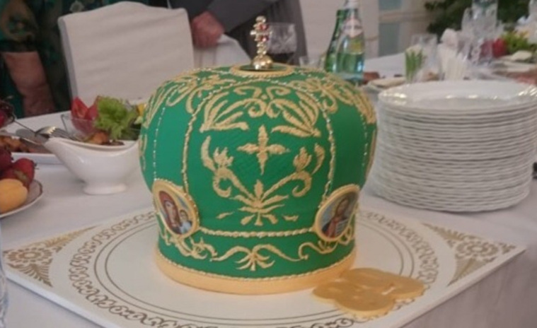 Торт украшен золотым крестом, по бокам — иконы