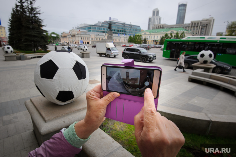 Горожане и гости города активно фотографируют огромные футбольные мячи