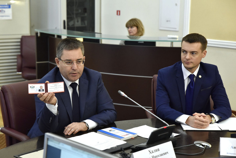Председатель облизбиркома Игорь Халин показывает губернаторское удостоверение Александра Моора