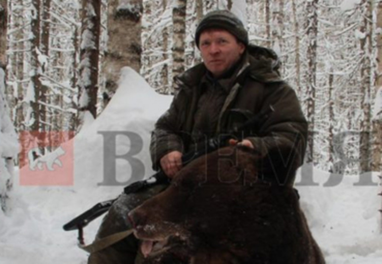 Василий Утробин позирует, сидя верхом на убитом медведе