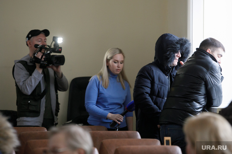 Руслан Рамазанов (возле окна) отказался общаться со СМИ. От камер его закрывает охранник (в капюшоне)
