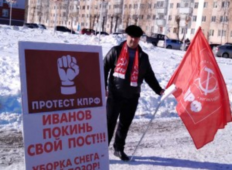 Коммунист Дмитрий Зеленский пикетирует на фоне заснеженной центральной площади Урая