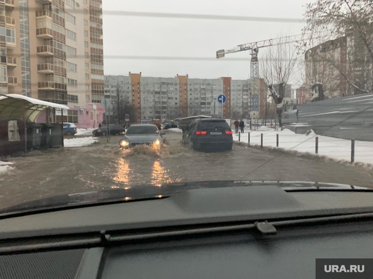 Машины буквально плывут по затопленной дороге