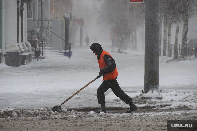 Рабочие убирают снег, несмотря на сложные условия