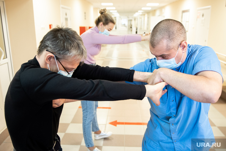 С теми пациентами, кто не может двигаться сам, инструктор по ЛФК Андрей Полетаев проводит «пассивно-активную гимнастику»