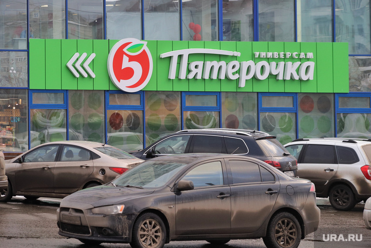 Благоустройство городского парка в снег. Курган , парковка автомобилей, магазин пятерочка