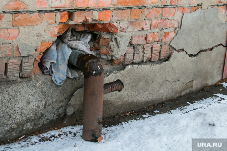 Разное. Курган, трещина в стене, трубы без утепления, стена дома, труба водопровода, разруха, труба отопления