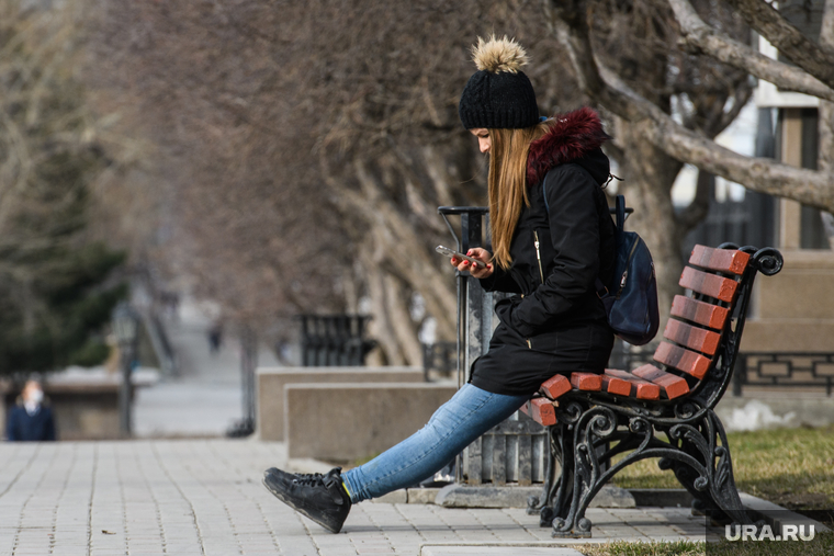 Десятый день вынужденных выходных из-за ситуации с CoVID-19. Екатеринбург, девушка на скамейке, смотрит в телефон