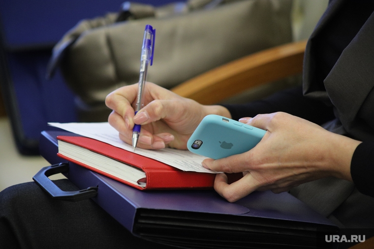Комитеты. Курган, чиновница, шариковая ручка, телефон в руках, запись в блокноте