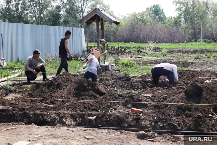 Рабочие копают ямы под фундамент для будущих домов