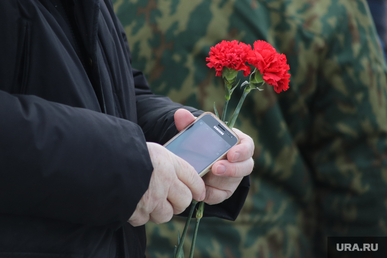Митинг посвященный 30-летию окончания выполнения боевой задачи советских войск в Афганистане. Курган, гвоздики, телефон в руке, цветок в руке