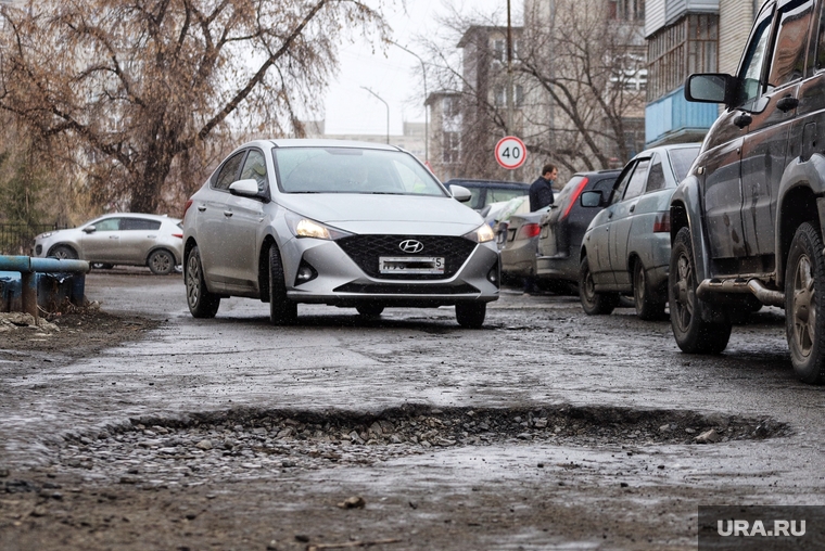 Выбоины на проезжей части. Курган, автомобили, яма, выбоина в дороге, дорога, разбитая дорога, выбоина
