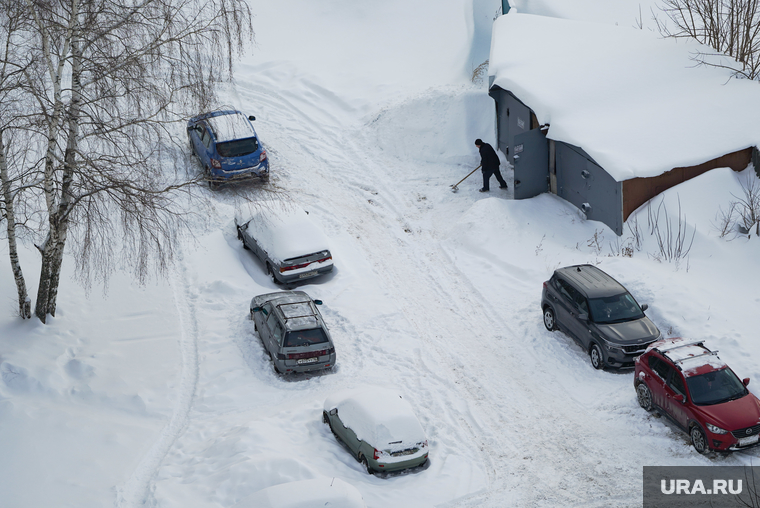 Автомобильная парковка во дворе жилого дома., снег, уборка снега, дворник с лопатой, гараж во дворе, гараж, последствия снегопада, парковка автомобилей, парковка, парковка во дворе, дворник