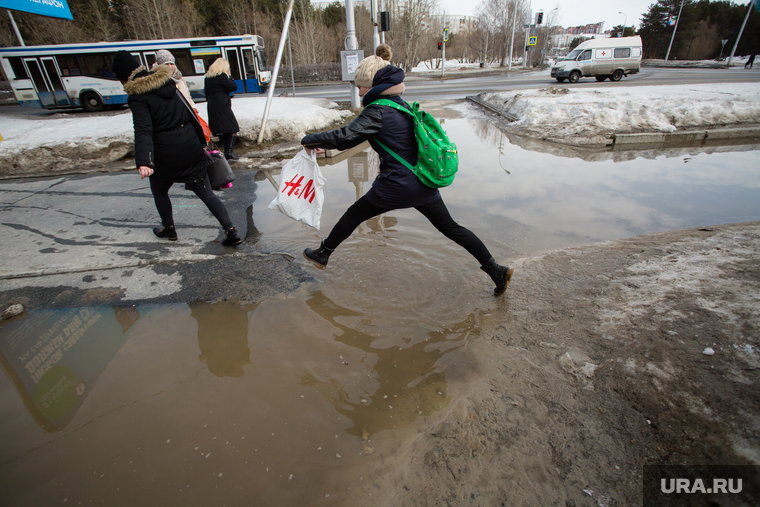 Дороги города весной. Сургут, лужи, пешеход в воде, весна