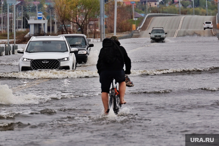 Некоторые курганцы предпочитают пробираться по затопленной дороге на велосипедах