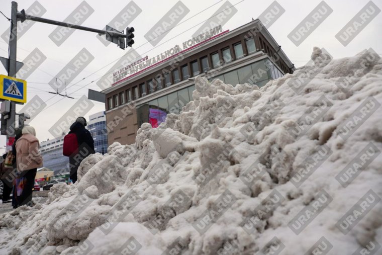Убранный снег собирают в огромные кучи