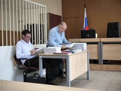 Игорь Минин (сидит) готовится к допросу в суде