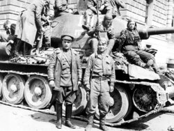 Советские солдаты и офицеры фотографируются у танка Т-34-85 на улицах освобожденной Праги