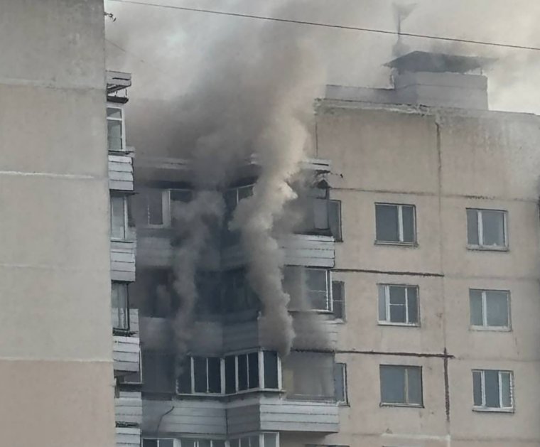 Из окна горящей квартиры валит густой черный дым