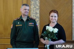 Под аплодисменты депутатов полковник Андрей Максуров вручил Лене Колесниковой букет и удостоворение участника СВО