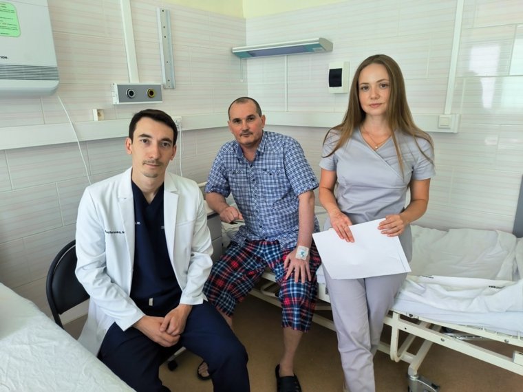 На этой неделе мужчина (в центре на фото) был выписан и отправился домой