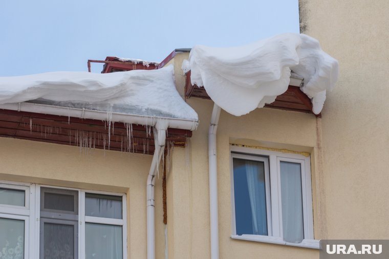 Снег свисает с крыши дома в Ноябрьске