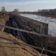 Бетонную стену поставили между незаконной высоткой и рекой в Кургане. Фото, видео