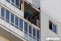 Мужчина стоял в окне балкона на втором этаже