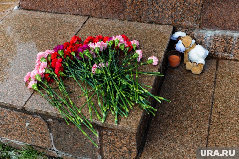 У памятника в память о погибших детях часто оставляют цветы, игрушки и свечи
