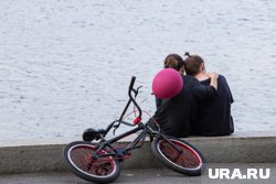 Двое в белых одеждах катаются по городу на велосипеде-карете