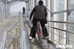 Дети играются на надземном переходе в Тюмени, у которого обвалилась обшивка 