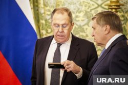 В ожидании президентов глава МИД России Сергей Лавров что-то зачитал с телефона помощнику президента Юрию Ушакова
