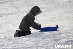 В Заозерном районе Кургана дети катаются с высокой песчаной насыпи на недостроенной улице 