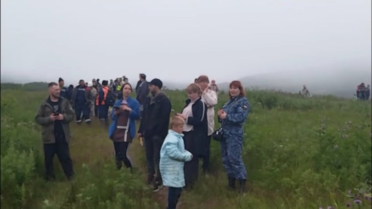 Люди находятся на возвышенности, ожидая, когда волны утихнут
