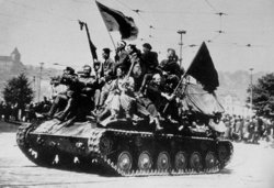 Красноармейцы и чешские повстанцы едут на броне САУ СУ-76М по набережной Влтавы в Праге