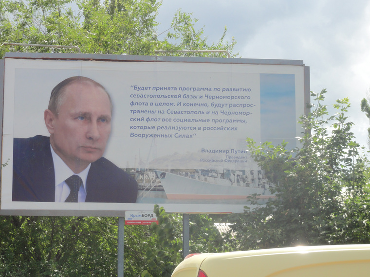 На одних плакатах Путин обещает развивать Крым и Черноморский флот с помощью федеральных программ.