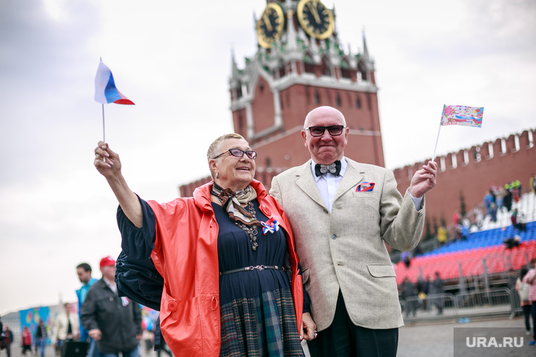 Первомайская демонстрация в Москве на Красной площади. Москва, пожилая пара, москвичи, флаг россии, красная площадь, пенсионеры